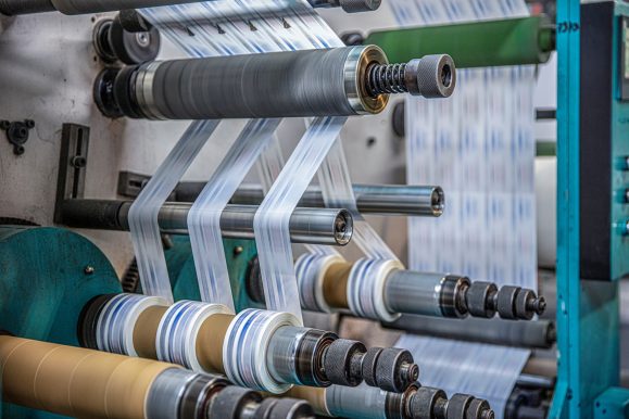 Rotary die cutting machine with slitting blade system. Production of duct tape.Packing tape manufacturing. Modern machine for packaging line in factory, Industrial and technology concept.